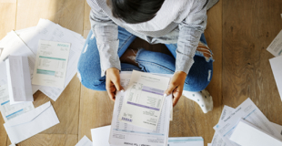 Person sitting on the floor amongst paperwork