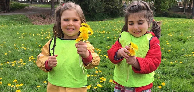 Two girls pick flowers in a field