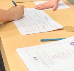 Person signing up to speak at the table located inside the Council Chamber