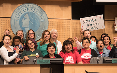 Councilmembers Teresa Mosqueda and Sally Bagshaw with domestic workers in Council Chambers.