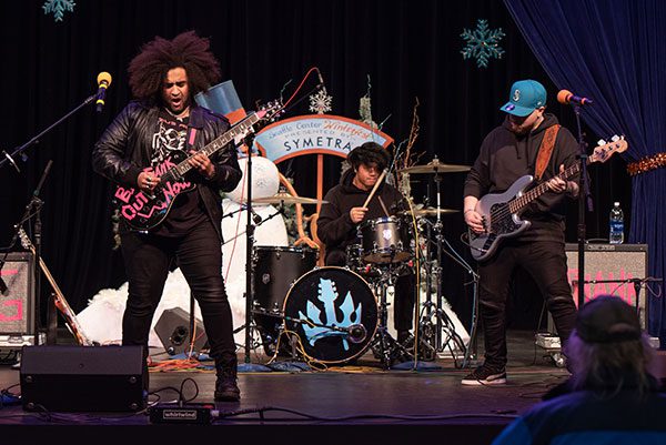 Three men of color play in a band onstage.