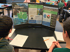 Two boys look at a hydropower information sheet
