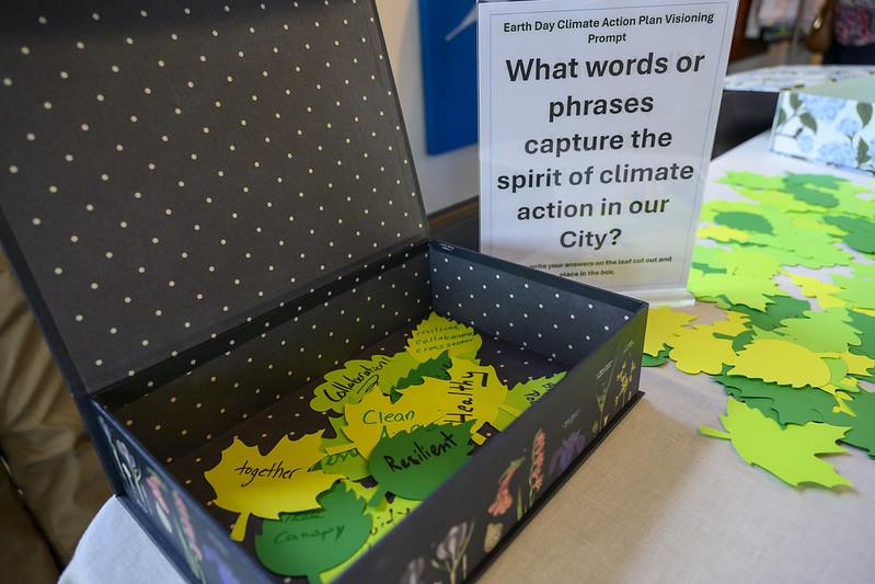a box filled with leaf shaped notes shaded in green on a display table