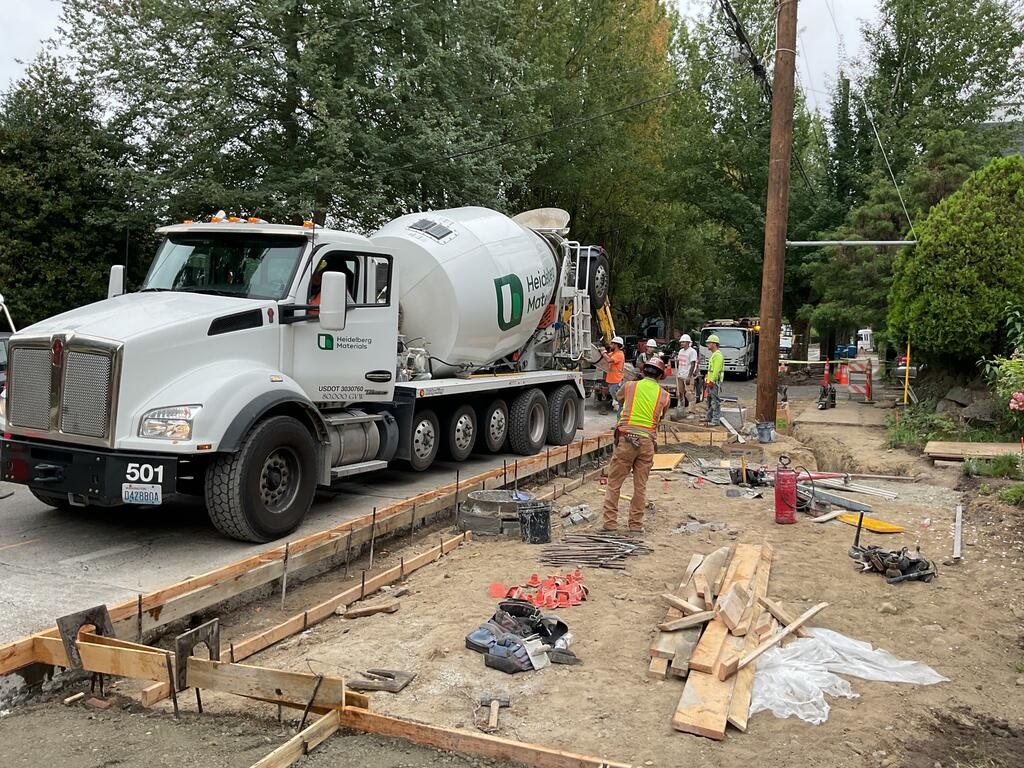 Crews pouring concrete for new curb and curb ramps near S Massachusetts St