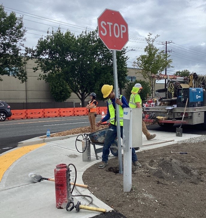 Crews installing signage on E Marginal Way S