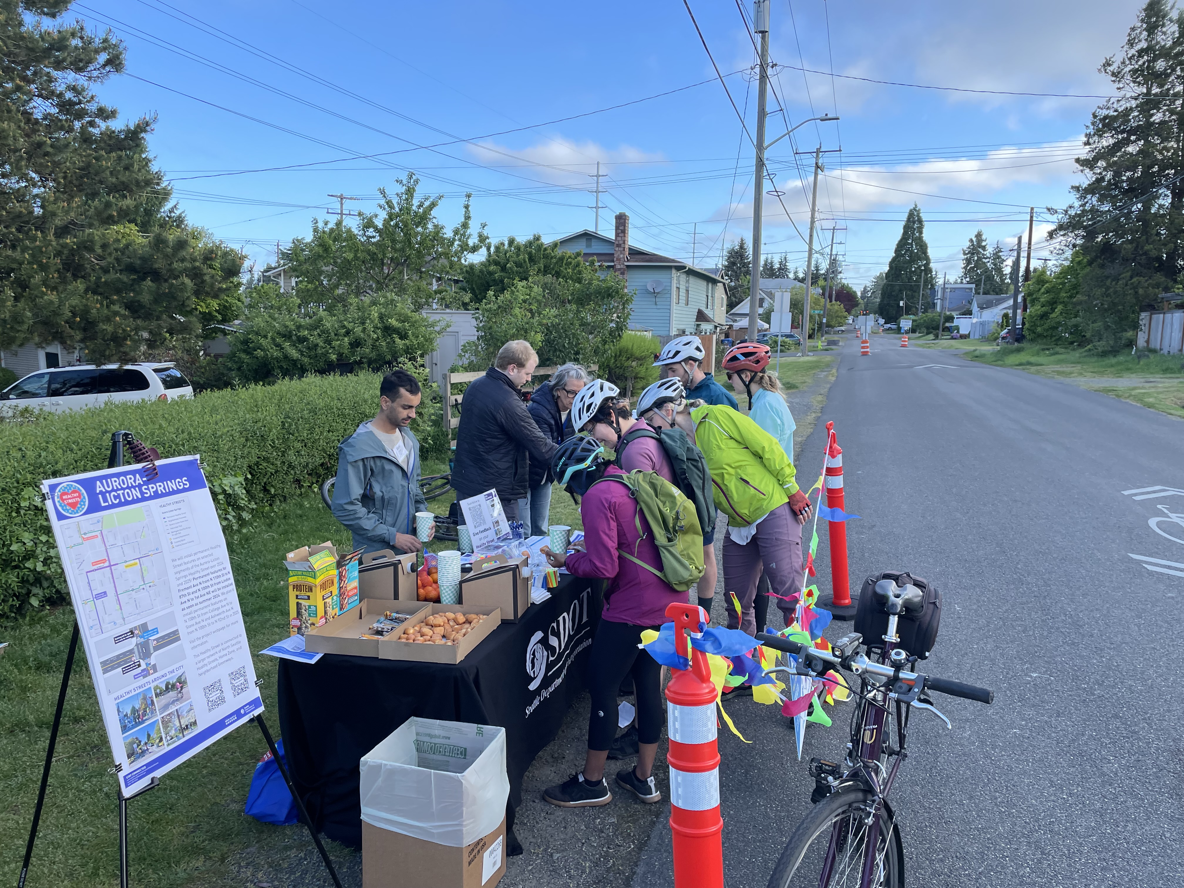 Bicycle riders stop by a station for snacks and to learn more about the Aurora-Licton Springs Healthy Street