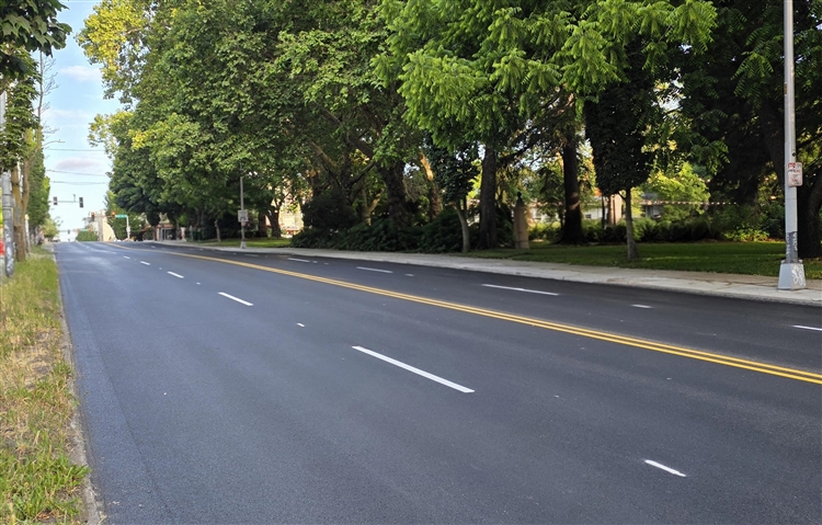 Image shows a section of Denny Way with new asphalt paving