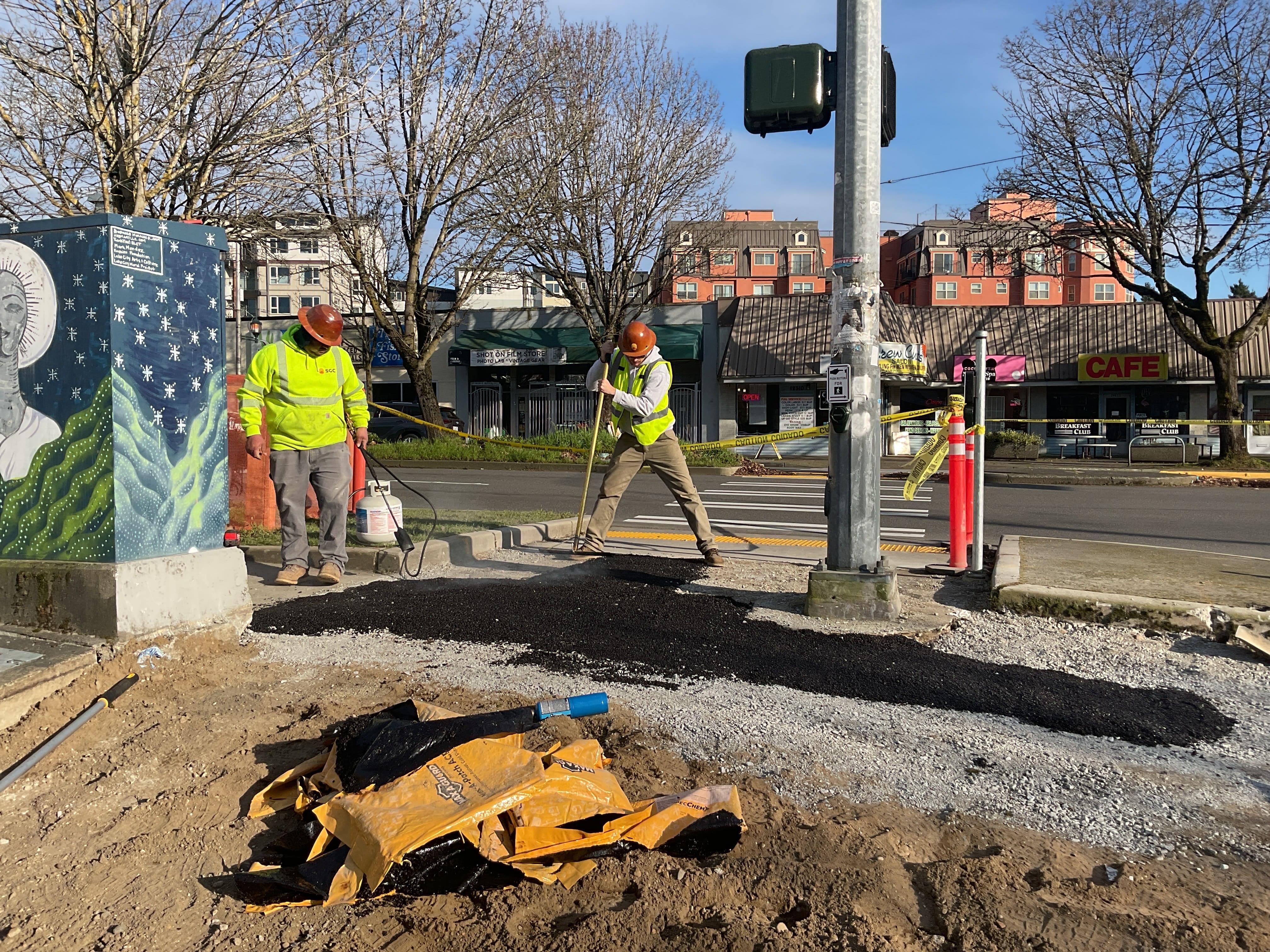 Crew members working to install a temporary sidewalk on the east side of 30th Ave NE.