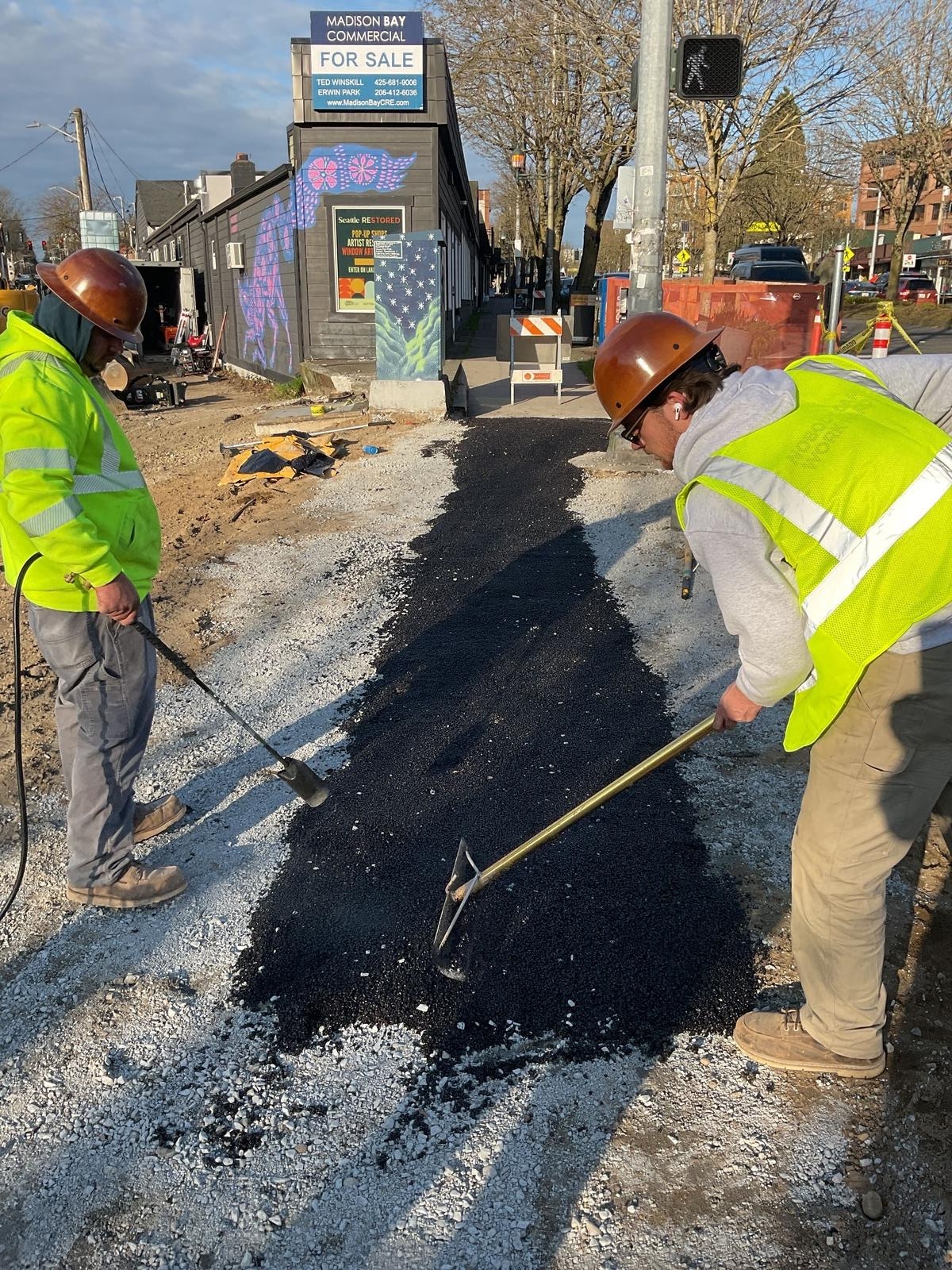 Crew members working to install a temporary crossing at 30th Ave NE and Lake City Way NE.