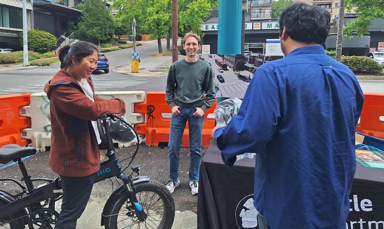 Image shows community members meeting staff members near Eastlake Coffee as we handed out free Lime helmets