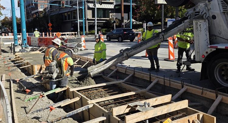 Image shows the team pouring new concrete foundations for the southbound RapidRide J Line station at E Lynn St