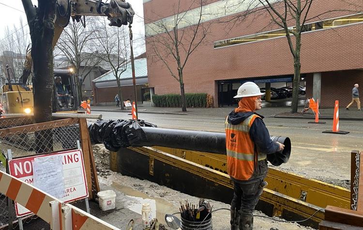 The image shows the team installing the last sections of new water main on Eastlake Ave E