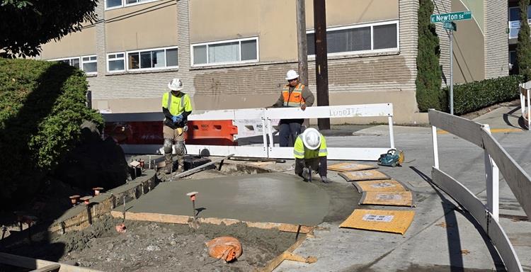 The image shows our team building new pedestrian ramps and areas of sidewalk near E Newton St along Eastlake Ave E. 