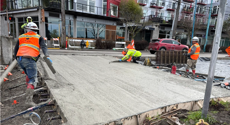 Image shows the team placing new concrete street panels along Eastlake Ave E