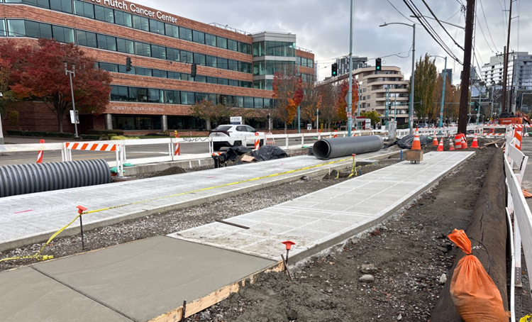 The image shows new concrete curing on Fairview Ave N as we construct new sidewalks and j Line stations