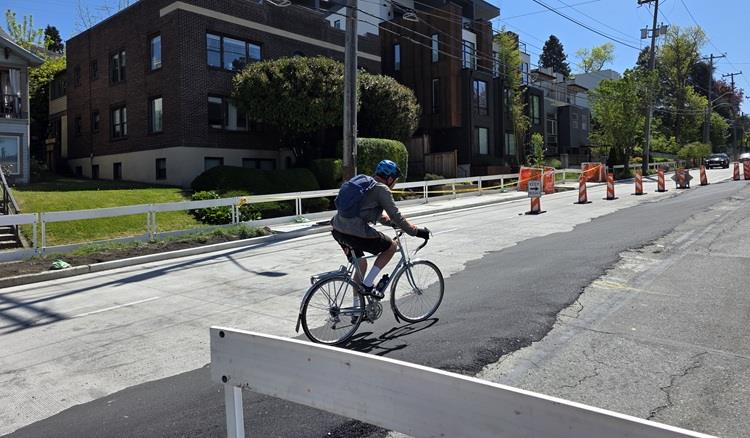 image shows a person riding their bike through our construction zone as we shift traffic for paving operations