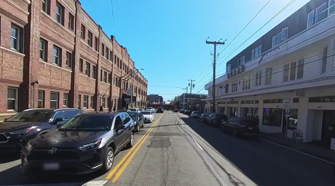 The image shows cars parked on both the east and west sides of Queen Anne Ave, facing south