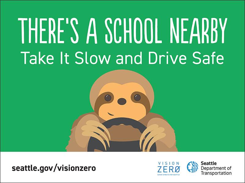 A sloth driving with the words 'There's a school nearby'