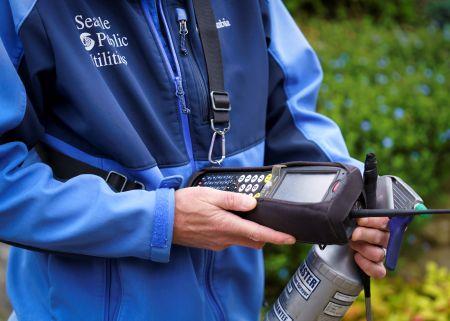 A meter reader holding work tools.