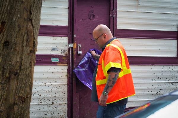 SPU employee with purple bag at door of RV.