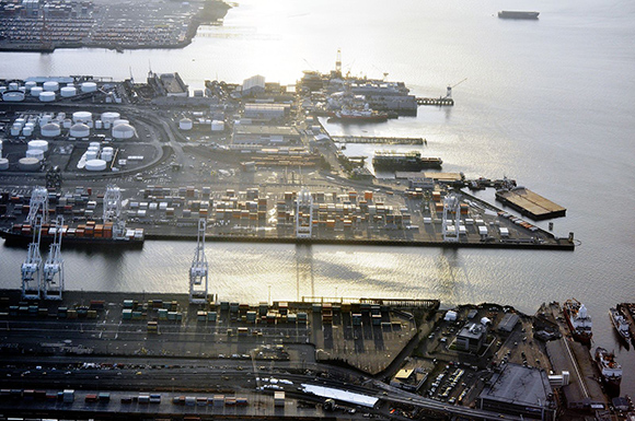 Westward view of Harbor Island with port operations, storage fuel tanks and various buildings and equipment at sunset.