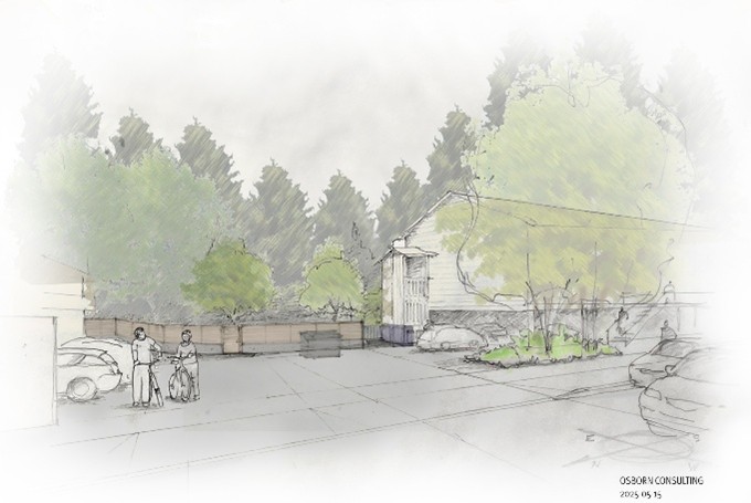 A parking lot between two buildings. A fence lines the back border of the lot and beyond the fence is a wall of trees of varying heights.