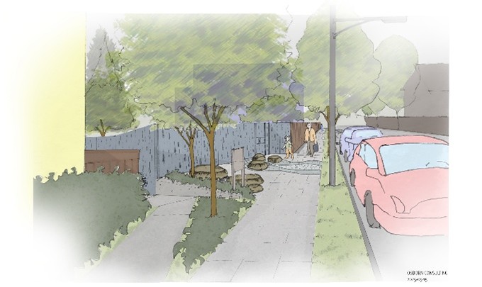 A concrete pathway lined by shrubs and small trees curves around the corner of a building and connects at an angle to a sidewalk next to a residential street with cars parked by the curb.