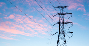 Powerlines backed by a pink cloud sunset skyline