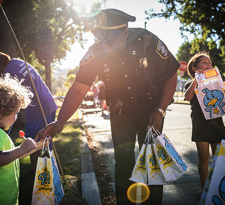 A Seattle police officer hands out bags of goodies to children