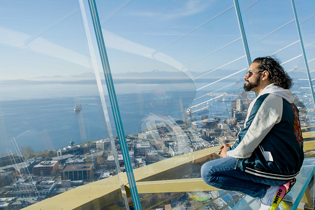 A man enjoying the Seattle cityscape views from the observatory deck of the Space Needle.