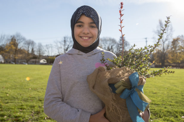 Girl wearing hijab holding a plant