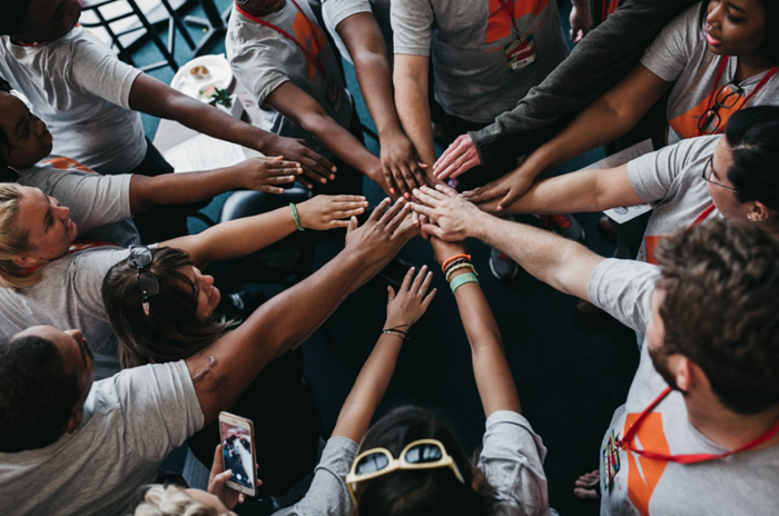 Hands all gathered in for a huddle Hands all gathered in for a huddle