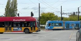 a streetcar and pedestrians waiting to cross at an intersection