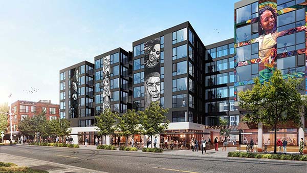 A 3-dimensional rendering of the exterior ofthe building from the street. The building is a dark color with large murals of people's faces on the outside of the building. Pedestrians are walking around the ground level. Trees line the sidewalk. The description of the image: Lifting up undervalued or disenfranchised voices connect the dots between developer and community leaders to create a design that reflects the community being served.