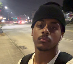 Selfie of krubel wearing a black beanie and white V-neck shirt.