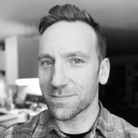 Robert has short hair and some scruff