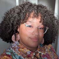 Cristina has curly hair and glasses