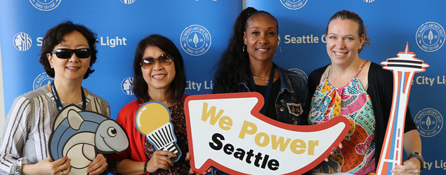 Four City Light employees pose with props