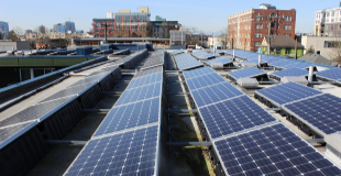 A solar array on top of the roof of a city building.