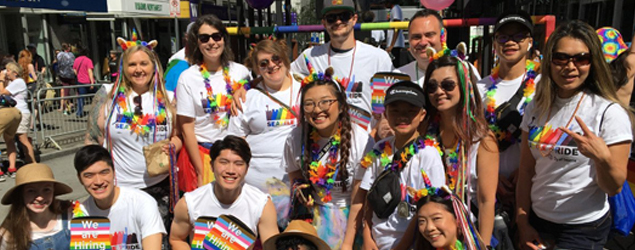 A group of employees pose at the Seattle Pride Parade