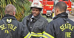 Photo of the chief speaking to two firefighters.