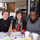 Three older women smiling for the camera during an Advisory Council retreat