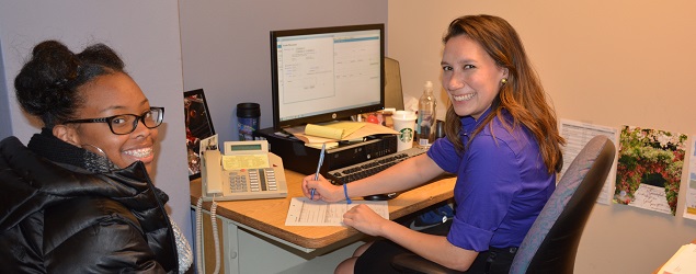 A Youth Development Counselor sits at a desk conducting a mock interview with an SYEP program participant
