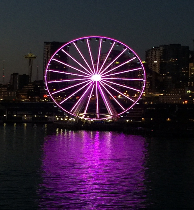 City staff wearing purple gathered near the Great Wheel on the Seattle Waterfront