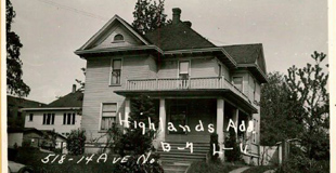Black and white photo of Cayton Revels wooden house with a large porch looking very old fashioned and cool.