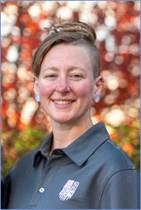 Headshot of Brittani Cain from the shoulders up smiling in polo shirt.  