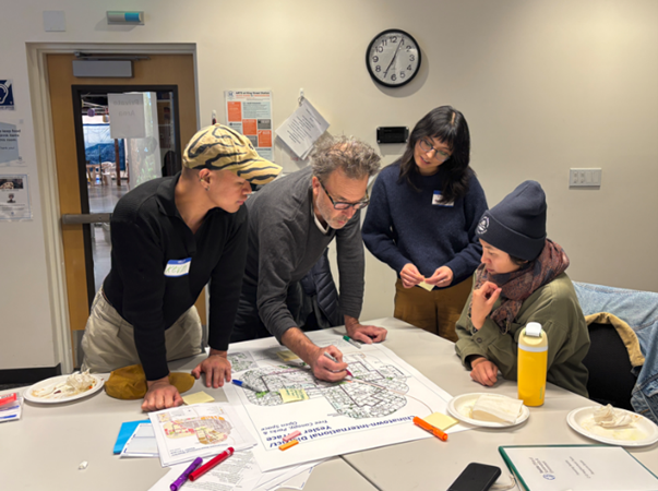 Team members gathered around a table and reviewing a map.