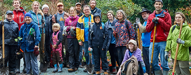 A group of people getting ready to do park cleanup. They are smiling for the camera.