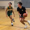 Two youth playing basketball