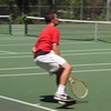 A man with a tennis racket on an outdoor court
